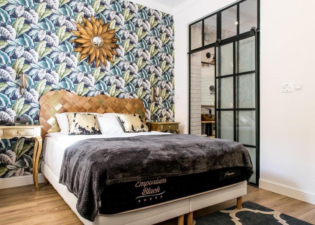 Schlafzimmer mit einem Bett mit Blumentapete in der Unterkunft ValdiArt Suites Old Town in Warschau