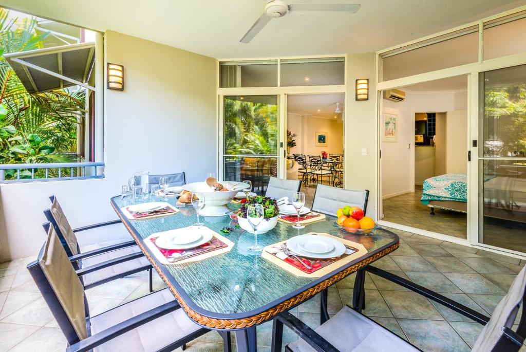 a dining room with a table and chairs at Palm Cove Holiday Apartment in Palm Cove