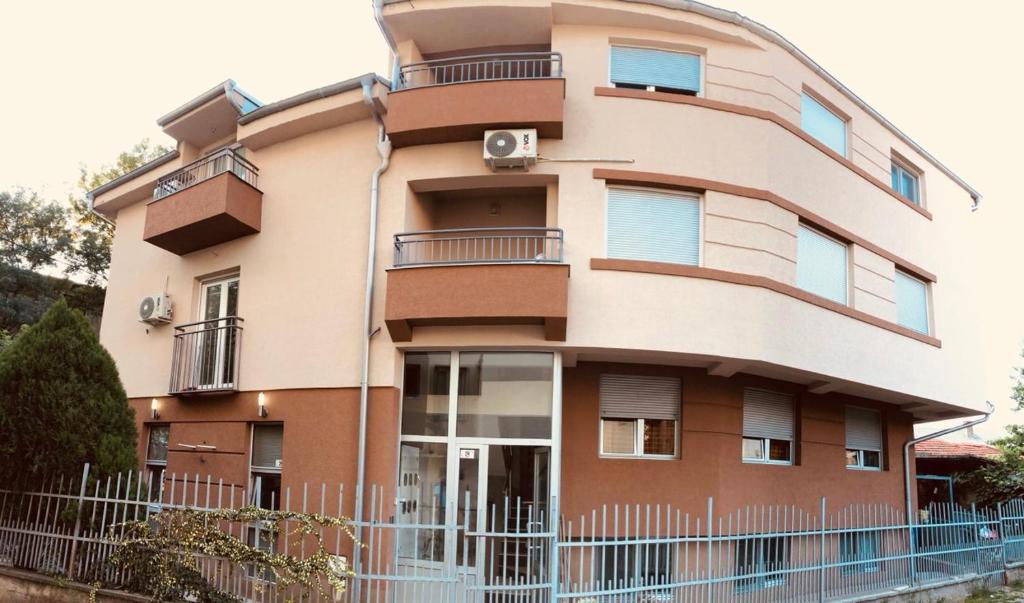 un bâtiment avec une clôture devant lui dans l'établissement Athos Apartments, à Niš