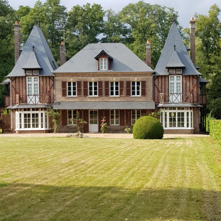 une grande maison avec une grande pelouse dans l'établissement Manoir du Chambellan, à Arnières-sur-Iton