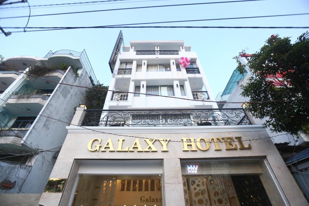 ein weißes Gebäude mit einem Schild mit einer Bordküche darauf in der Unterkunft Galaxy Hotel in Ho-Chi-Minh-Stadt