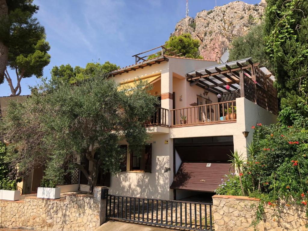 ein Haus mit einem Balkon mit einem Berg im Hintergrund in der Unterkunft Mediterrania 98 in Torroella de Montgrí