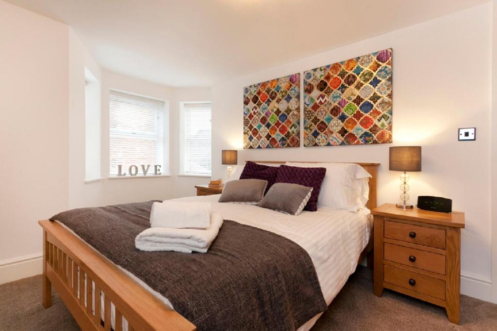 ノッティンガムにあるBowling Green Apartment - West Bridgfordの大きなベッド付きのベッドルーム1室、壁に絵画が飾られています。