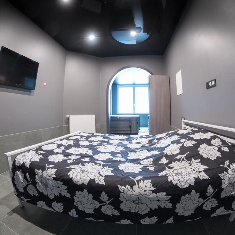 a bedroom with a large bed with a black and white blanket at Appartement Studio Tournai in Tournai