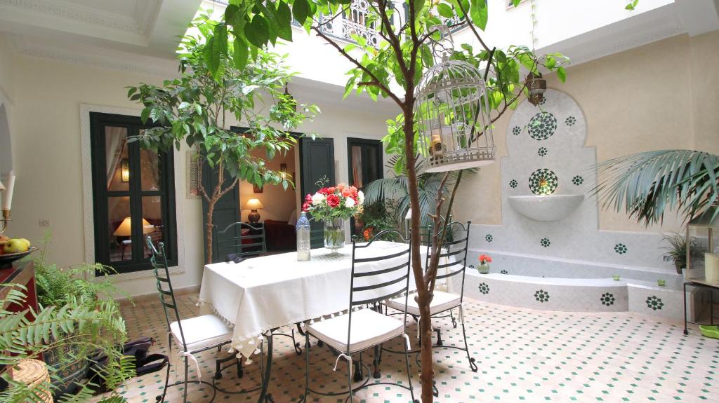 a table and chairs in a room with plants at Riad Kasbah Baraka in Marrakesh