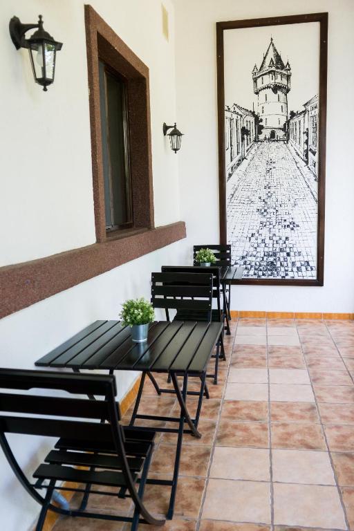 a dining room with benches and a drawing on the wall at Nest in Drobeta-Turnu Severin