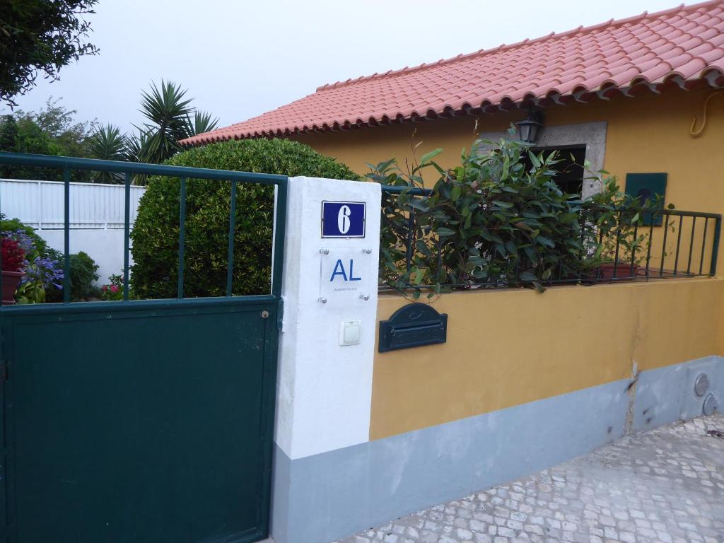 a gate to a house with a door with the number at it at Casinha Amarela in Sintra