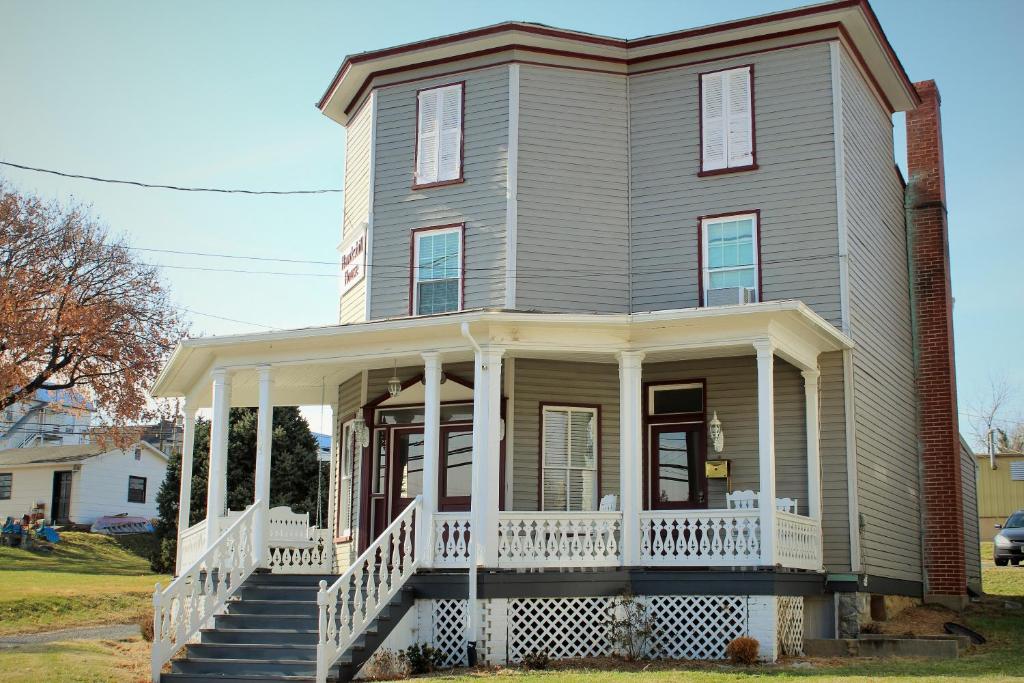 a gray house with a white porch and stairs at Hawksbill House - (Adults Only) in Luray