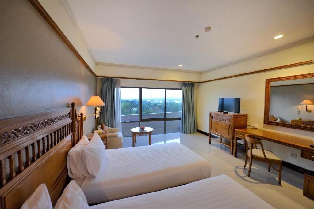 Postel nebo postele na pokoji v ubytování Loei Palace Hotel