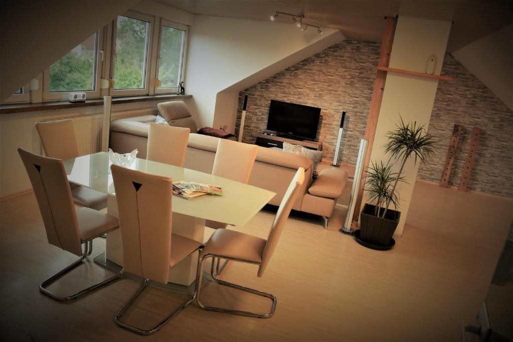 uma sala de estar com uma mesa e cadeiras e um sofá em Lichtenau - Bertholdes Traum em Lichtenau