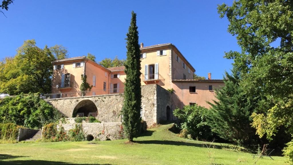 Château de la Cazette في سيسترون: منزل كبير أمامه شجرة