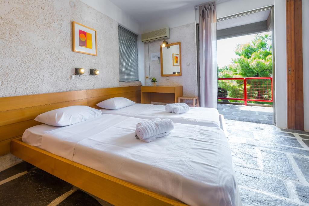 a bedroom with a bed with two towels on it at Apollonia Hotel Apartments in Varkiza