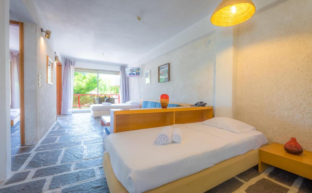 a bedroom with a bed and a living room at Apollonia Hotel Apartments in Varkiza
