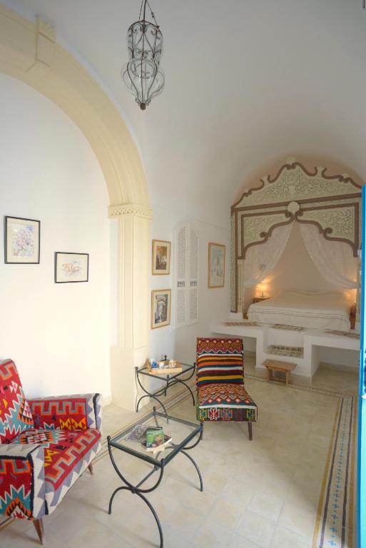 een woonkamer met 2 stoelen en een bank bij Dar R'Bat, Maison d'Hôtes de charme in Nabeul