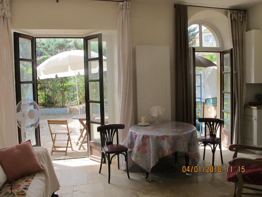 un salon avec une table, des chaises et un canapé dans l'établissement L'Ancien Couvent sur jardin, havre de paix en centre ville à 100m de la mer avec parking privatif, à Sète