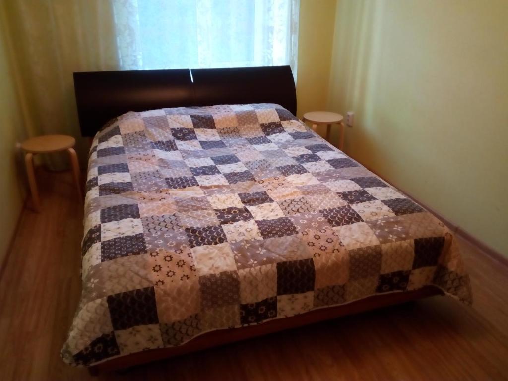 een bed met een dekbed in een slaapkamer bij Apartament Ленина 47 in Balasjicha