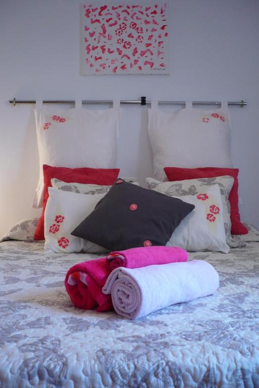 un animal de peluche tirado en una cama con almohadas en Habitación La Luz, en Granada