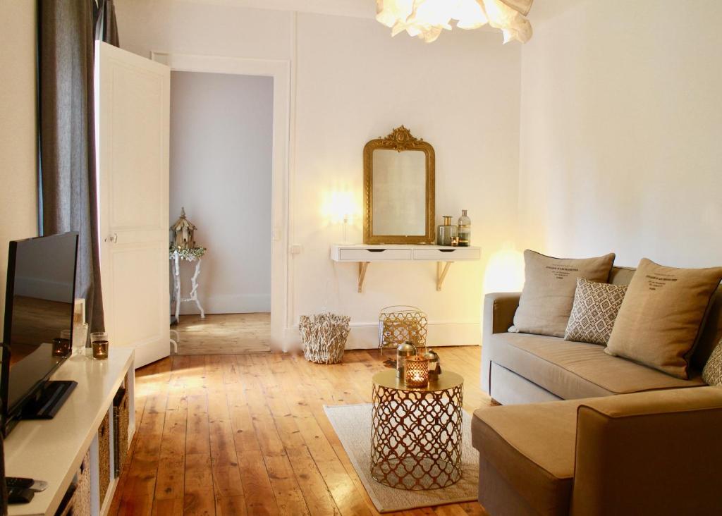 - un salon avec un canapé et un miroir dans l'établissement La Maison Au Bois Dormant, à Barraux