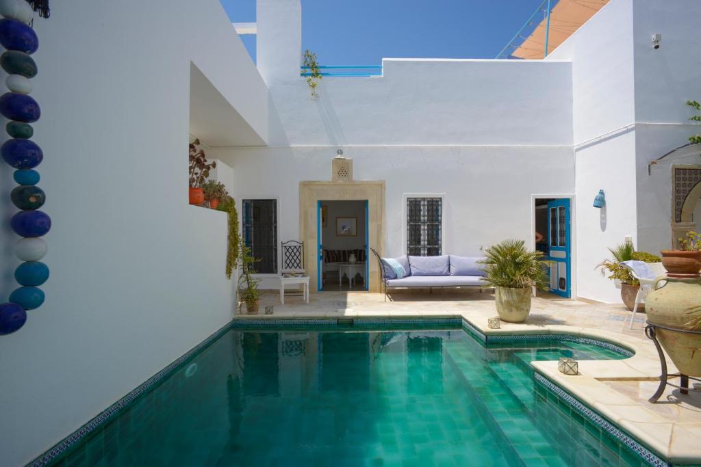een zwembad in een huis met een woonkamer bij Dar R'Bat, Maison d'Hôtes de charme in Nabeul