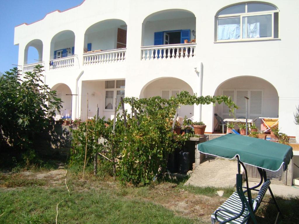 ein weißes Haus mit einem grünen Tisch davor in der Unterkunft Villa Leonardo in Ischia