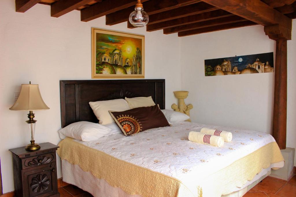 a bedroom with a large bed with two pillows on it at Hotel Real Antigua in Antigua Guatemala