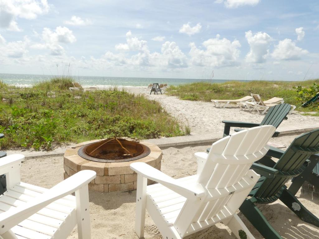 two chairs and a fire pit on the beach at Sand Glo Villas in Clearwater Beach