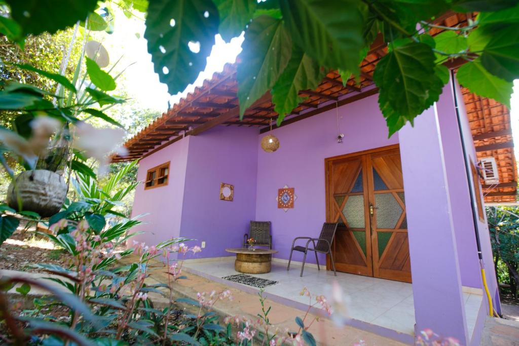 a house with purple walls and a wooden door at Chalés Ima Teva in Lençóis