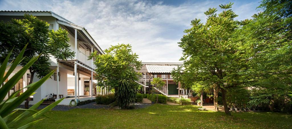 an exterior view of a house with trees in the yard at Krodyle Mindfulness House in Phra Nakhon Si Ayutthaya