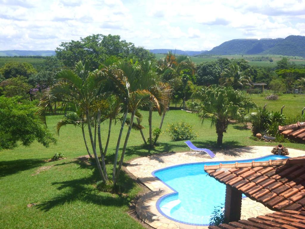 a swimming pool in a yard with palm trees at Recanto de Oryon in São Pedro