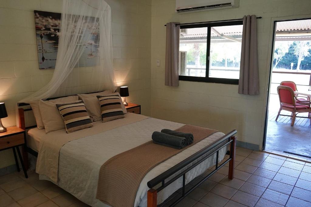 a bedroom with a large bed and two chairs at Point Stuart Wilderness Lodge in Point Stuart