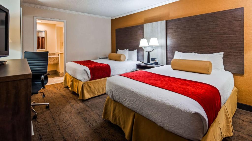 a hotel room with two beds and a desk at Best Western Galleria Inn & Suites in Cheektowaga