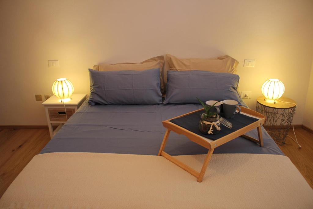 una camera con un letto con un tavolo e due lampade di Delizioso Appartamento Centro Storico Lucca Comics a Lucca