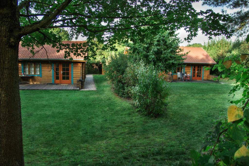 ein Hof mit einem Haus und ein Haus mit einem Baum in der Unterkunft Ferienhaus am Zylinderberg in Zislow