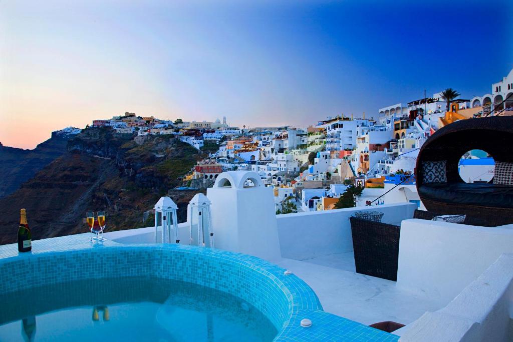 a pool with a view of a town with white buildings at Blue Angel Villa in Fira