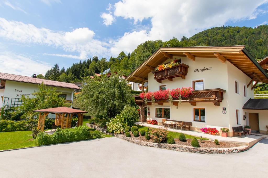 einen Blick nach außen auf ein Haus mit Garten in der Unterkunft Bergheim Komfort Ferienwohnungen in Walchsee