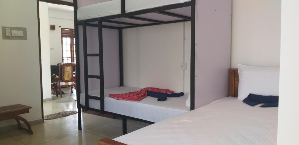 a bedroom with two bunk beds and a mirror at I & I Hostel in Mirissa