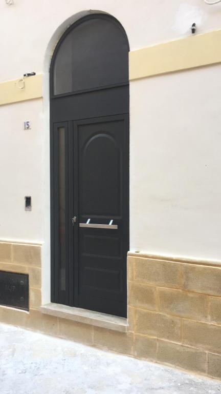una porta nera sul lato di un edificio di B&B MARIO PAGANO a Brindisi