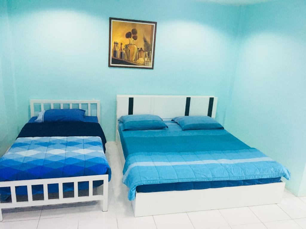 2 camas en una habitación con paredes azules en Best Rent a Room, en Nai Yang Beach