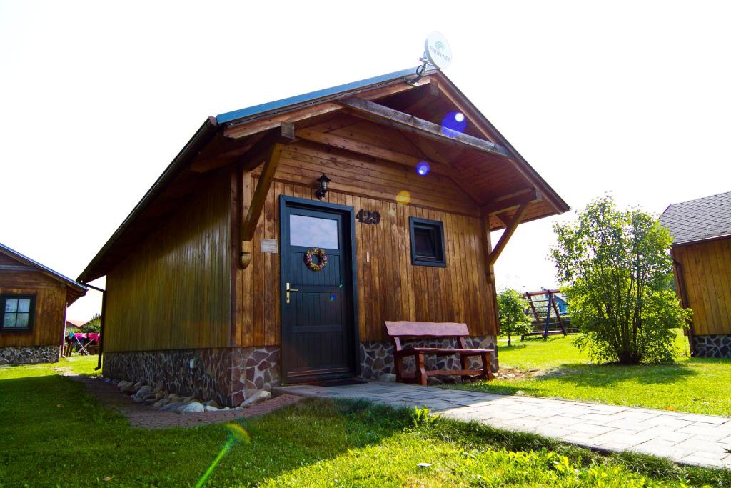 Cabaña de madera pequeña con puerta y banco en Chatka 428 a 429 - Tatralandia, en Liptovský Mikuláš