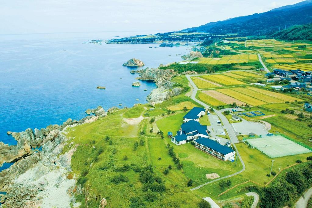 an aerial view of a farm next to the water at Hotel Familio Sadoaikawa in Sado