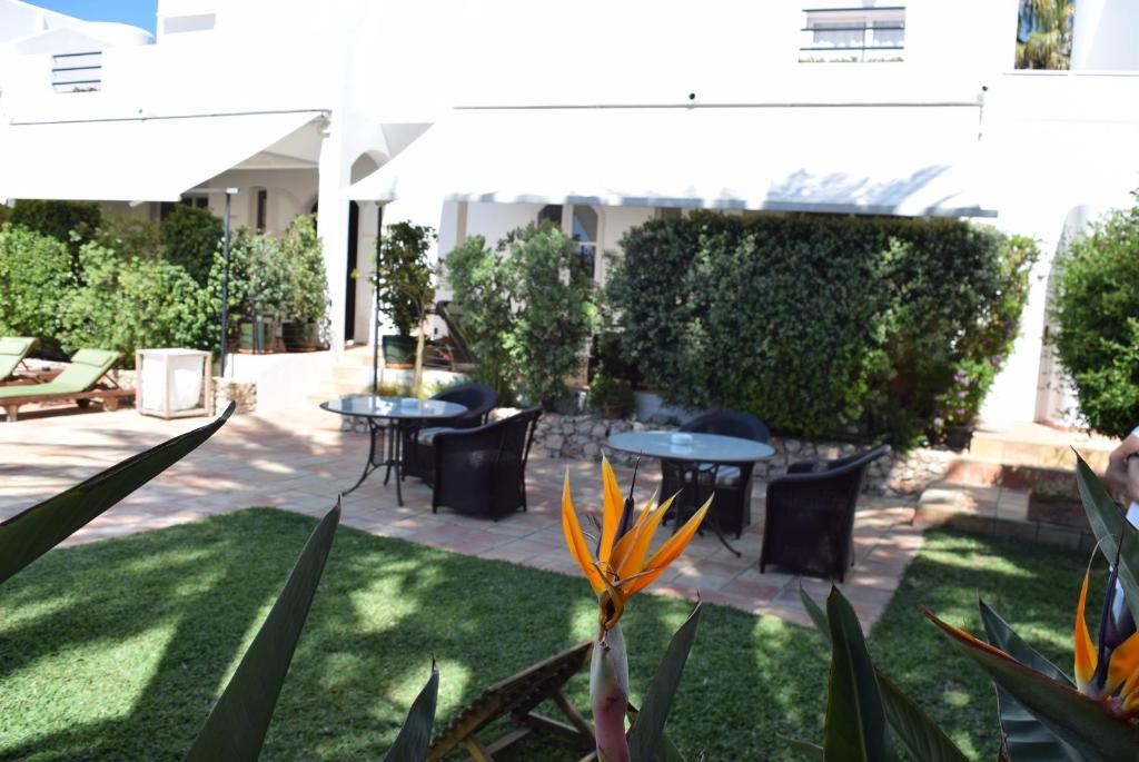 a patio with tables and chairs in a yard at miKasa Agua Amarga & SPA in Agua Amarga