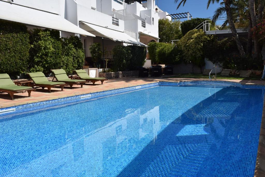 a large swimming pool with chairs and a building at miKasa Agua Amarga & SPA in Agua Amarga