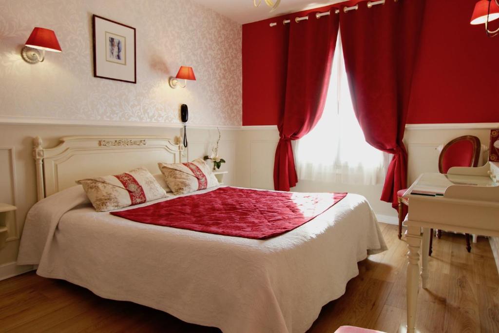 a bedroom with a bed with red walls and a window at Hôtel Chopin in Paris