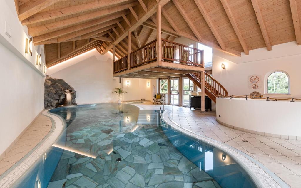 - une piscine intérieure dans une maison dotée d'un plafond dans l'établissement Sporthotel Exclusive, à San Vigilio Di Marebbe