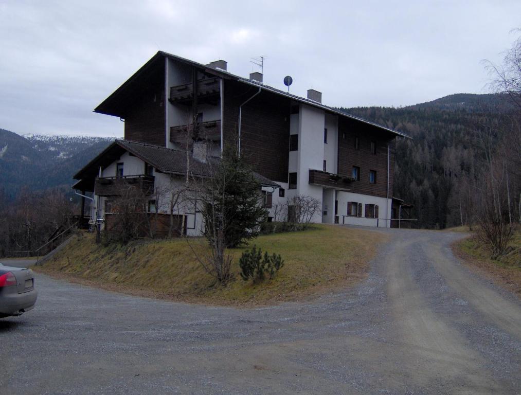a house on top of a hill next to a road at Fewo Nr. 15 Haus Konradgut in Sankt Lorenzen ob Murau