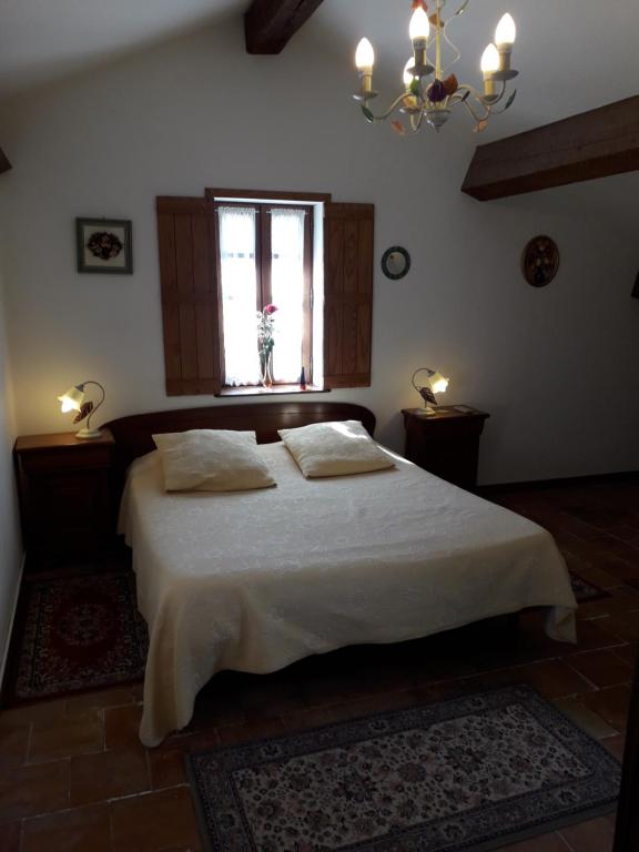 a bedroom with a bed with two pillows and a window at Domaine de la Pinsonnière in La Livinière