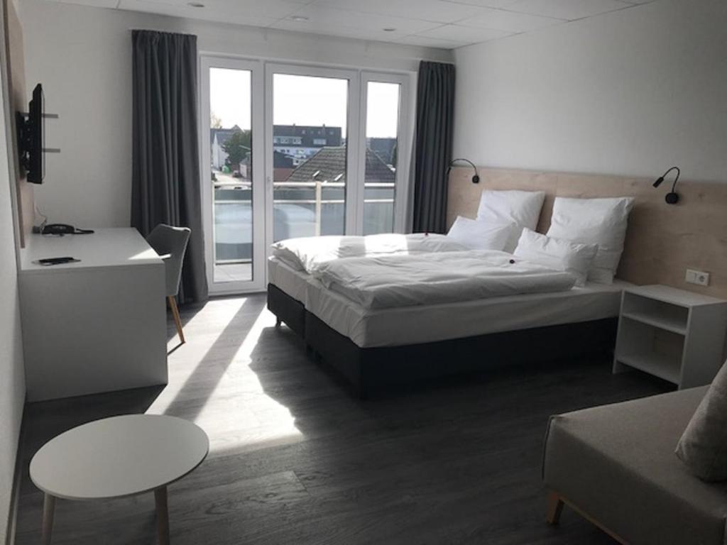 Habitación de hotel con cama y balcón en Hotel an der Burgschänke en Alpen