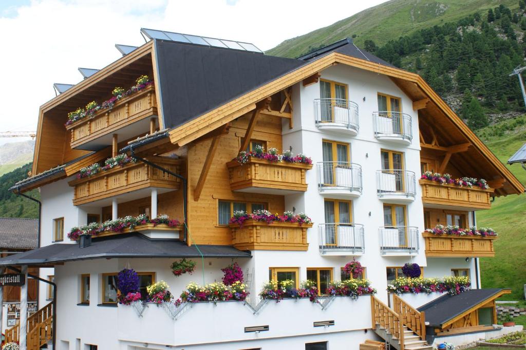 un edificio con balcones y flores. en Haus Bergkristall, en Obergurgl