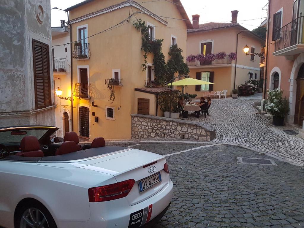 a white car parked on a street with buildings at Scaccia pensieri in Cerchio