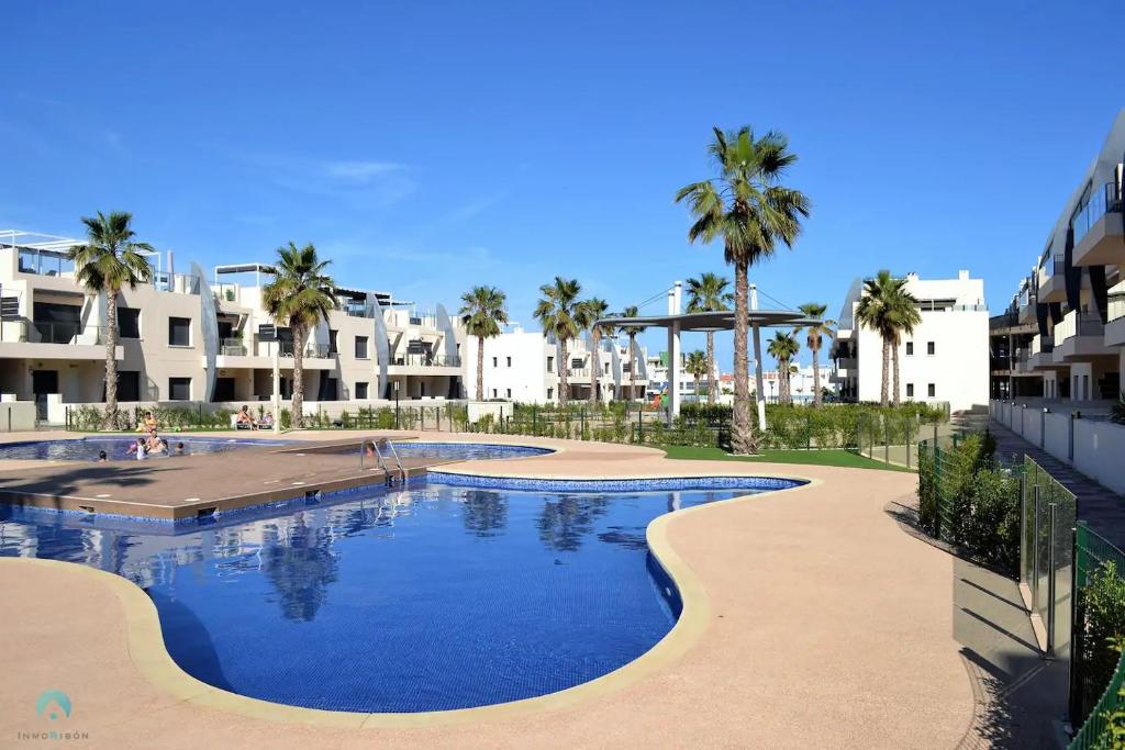 皮拉爾德拉奧拉達達的住宿－New Luxury Detached Villa with pool at beach，一座棕榈树和建筑的大型游泳池